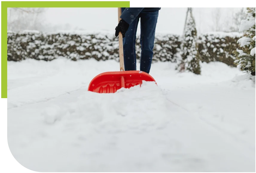A person removing snow with a red shovel